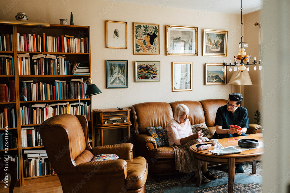 Young male nurse spending leisure time while playing cards at home Young male nurse spending leisure time while playing cards at home