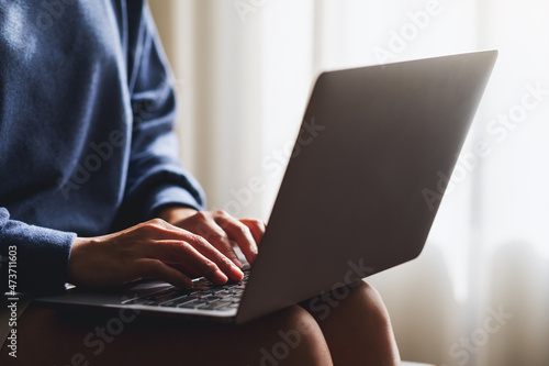 Closeup of a woman working and typing on laptop computer keyboard