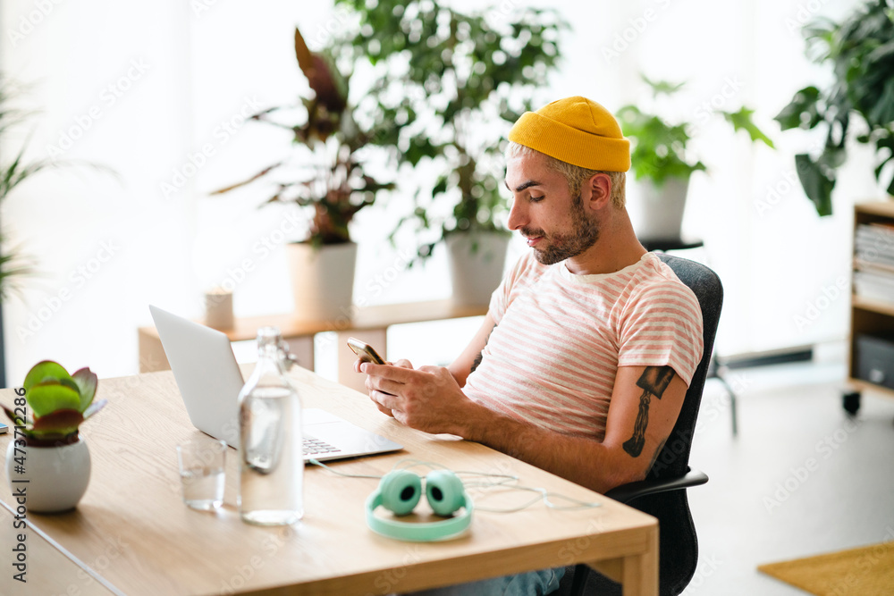 Trendy freelancer using smartphone during work Trendy freelancer using smartphone during work