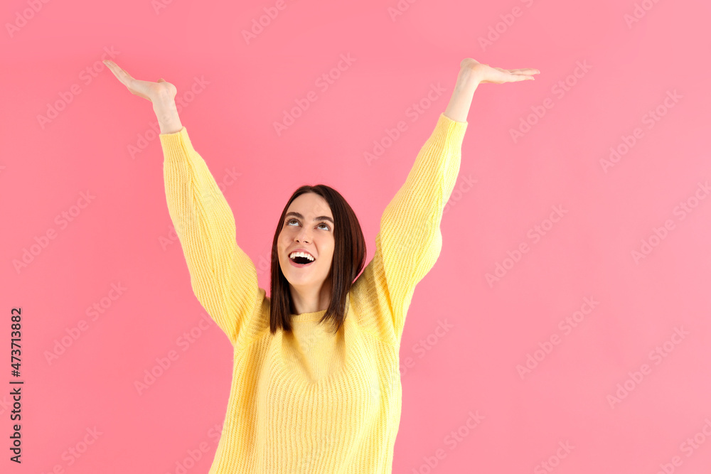 Attractive girl in yellow sweater on pink background Attractive girl in yellow sweater on pink background