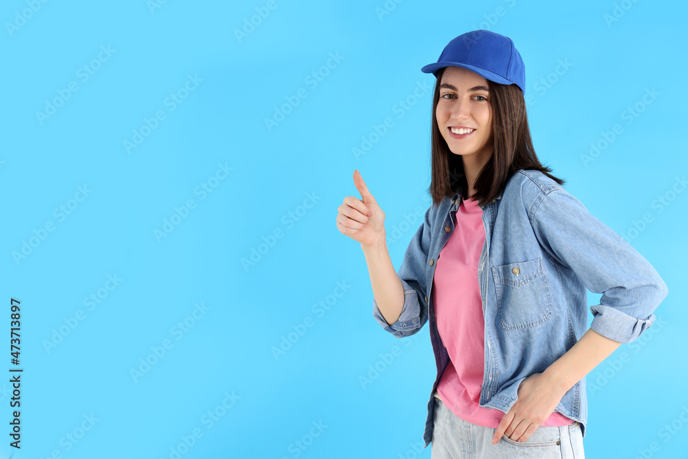 Attractive girl in cap on blue background