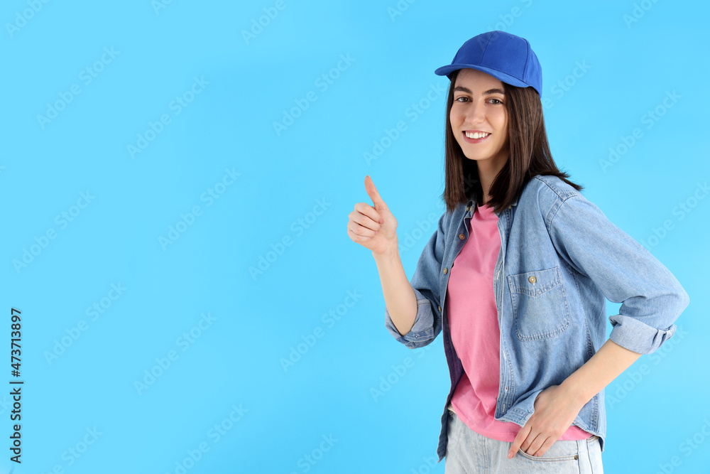 Attractive girl in cap on blue background