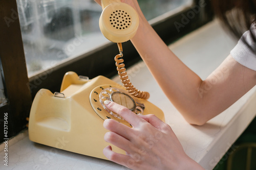 Woman hand using an old phone.