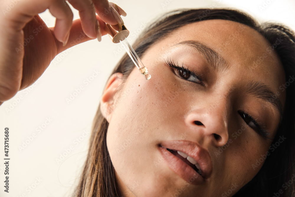 Beautiful model using face serum dropper Stock Photo Adobe Stock