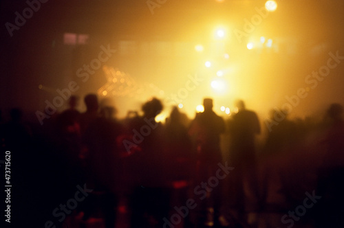 Anonymous people silhouettes dancing during a party photo