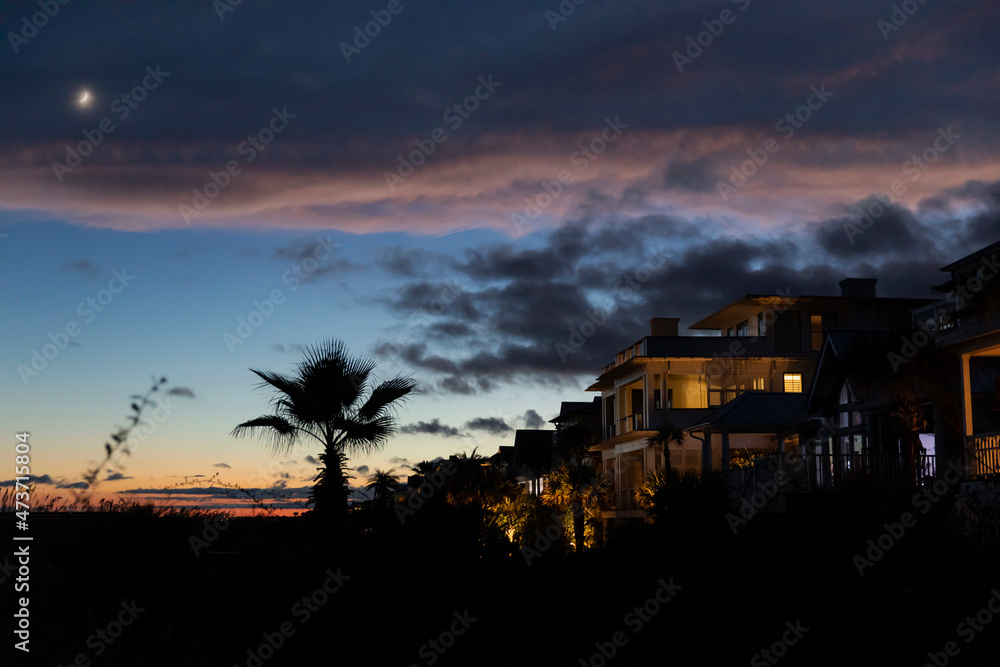 Crescent Moon sunset at beach with waterfront homes Crescent Moon sunset at beach with waterfront homes