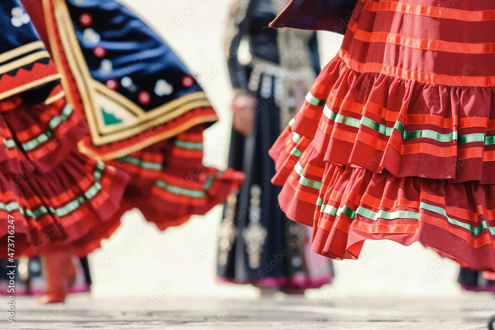 Decorated traditional Bashkir skirt flutters in folds during the dance with spinning red boots in the foreground
