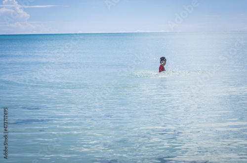 child splash the water at the beach