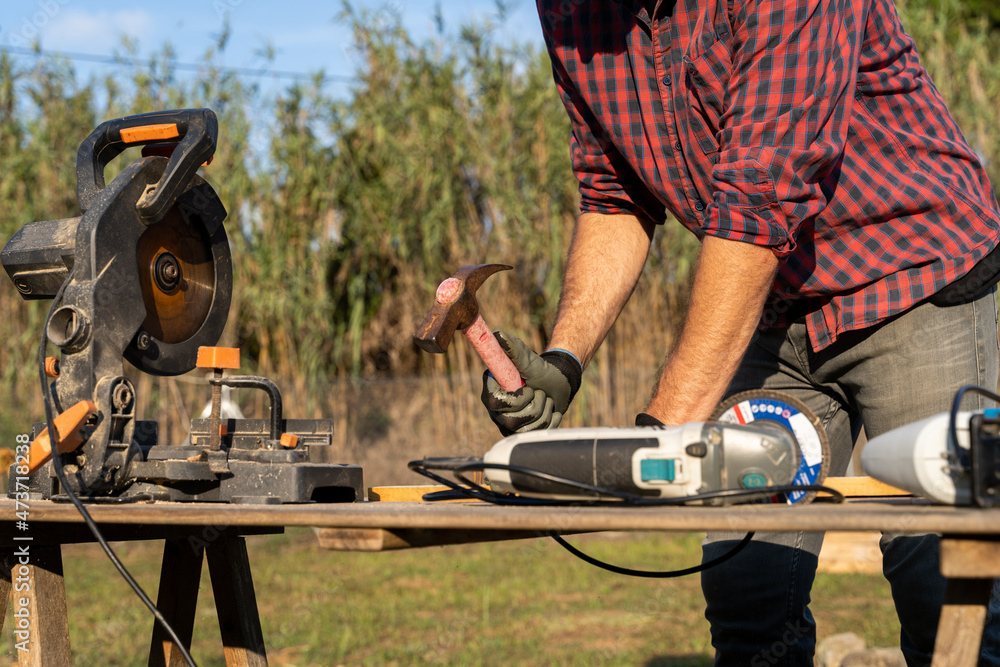 Crop image of Man removing nails from pallet outdoors Crop image of Man removing nails from pallet outdoors