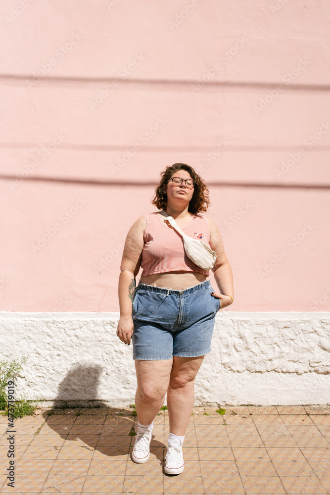 Young woman posing in front of a pink wall Young woman posing in front of a pink wall