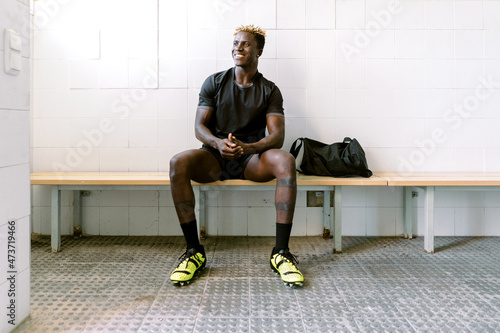 Black male footballer in changing room photo