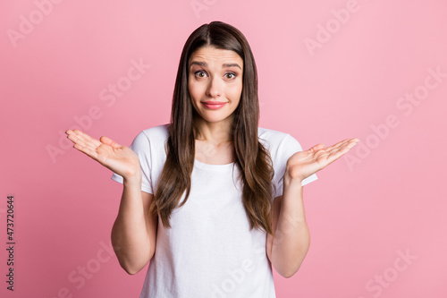 Portrait of attractive cheerful confused girl shrugging shoulders why isolated over pink pastel color background © deagreez
