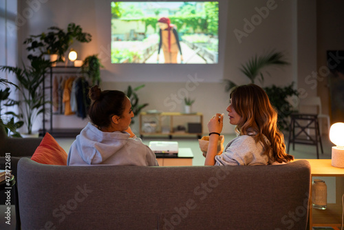 Anonymous women watching movie on projector photo