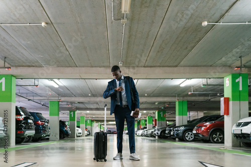 Businessman looking at time in airport car park photo