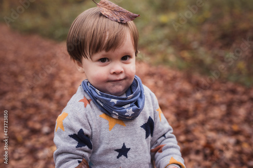 Germany, Baden-Wurttenberg, Lenningen, Portrait of little boy standing outdoors with fallen leaf on top of head photo