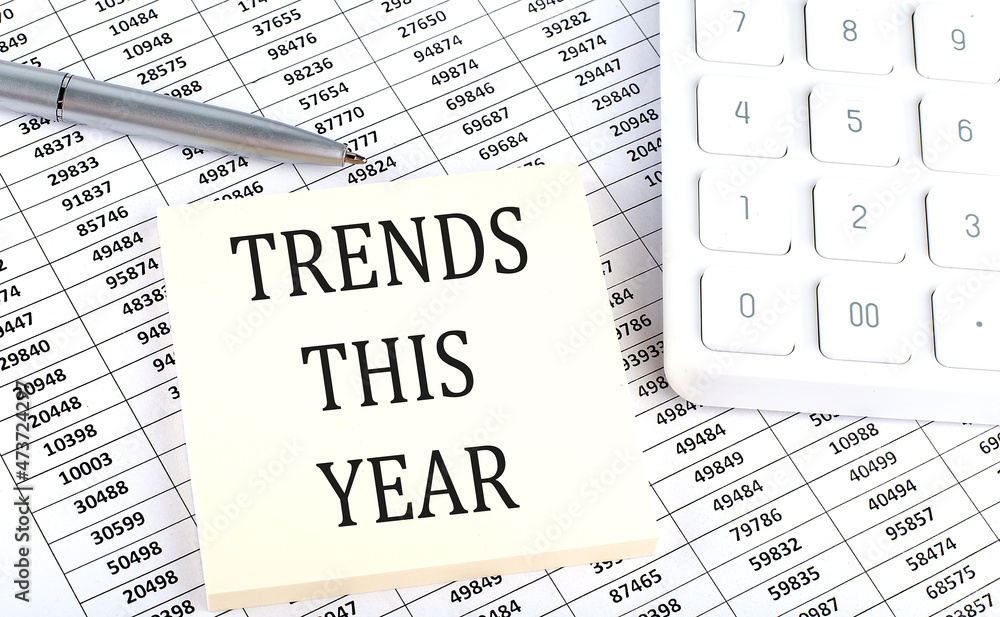 TRENDS THIS YEAR - business concept, message on sticker on chart background TRENDS THIS YEAR - business concept, message on sticker on chart background