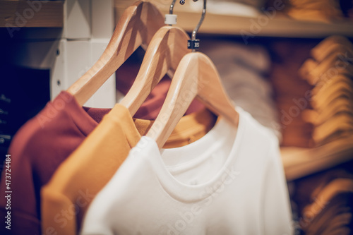 T-shirts on hangers. Stacks of clothes. Shopping in store. Clothes on hangers in shop for sale