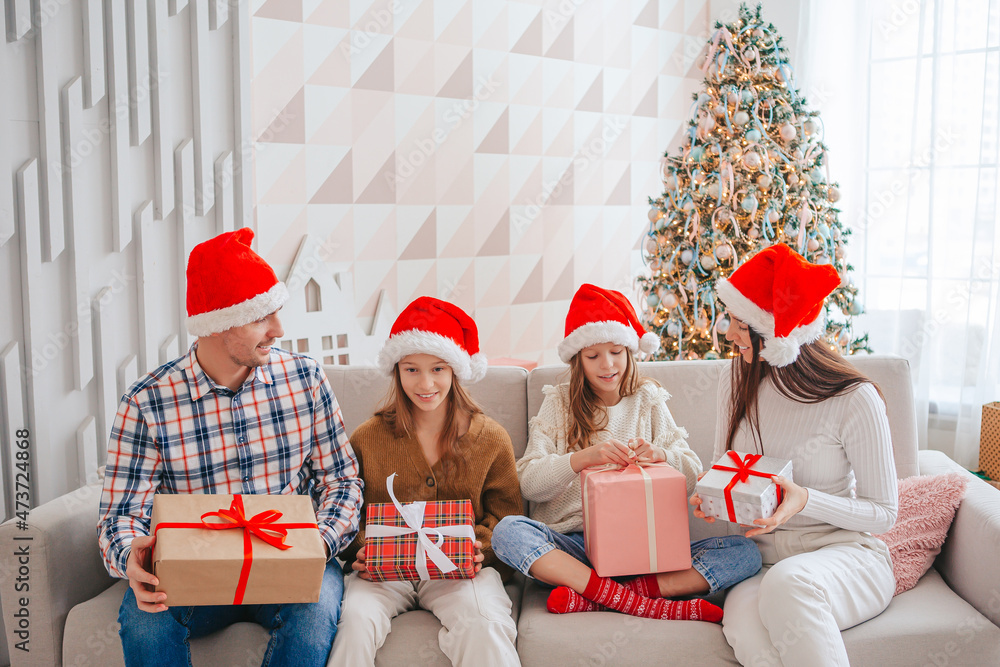 Fototapeta premium Happy young family with kids holding christmas presents