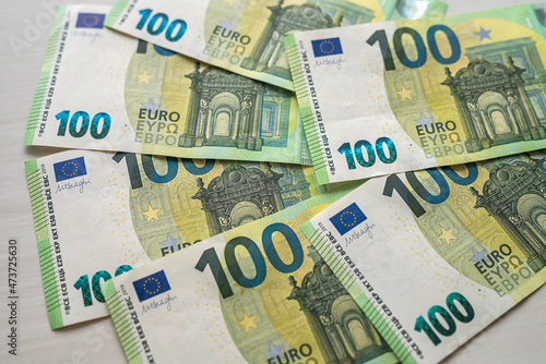 beautiful new 100 euro banknotes laid out on a spacious table