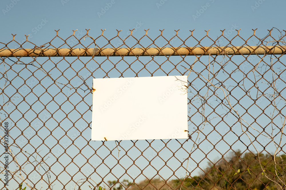 Blank White Sign with Fence and Blue Sky Blank White Sign with Fence and Blue Sky
