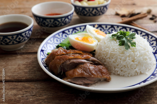 Local Thai food stewed pork leg on rice isolated in wood background