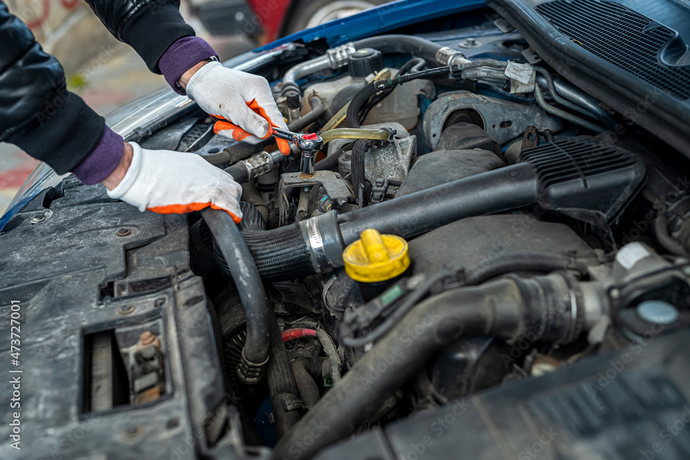 close up of mechanic hand using wrench to service car for repair or check engine close up of mechanic hand using wrench to service car for repair or check engine