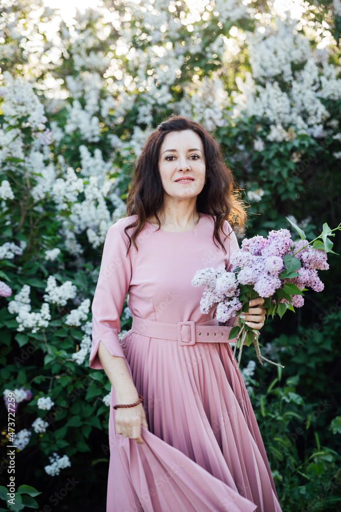 beautiful brunette woman in a dress with lilac flowers beautiful brunette woman in a dress with lilac flowers