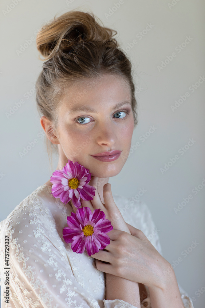 Young woman with purple flowers contemplating in studio Young woman with purple flowers contemplating in studio