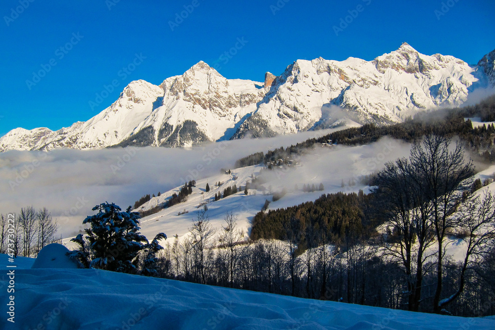 Fototapeta premium Winter landscape, stunning mountain range, snowy trees and blue sky at Maria Alm, Hinterthal in Austria
