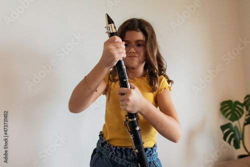 Girl struggling to assemble clarinet.  photo