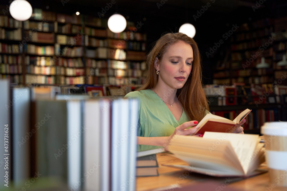 Young woman reading book in library Young woman reading book in library
