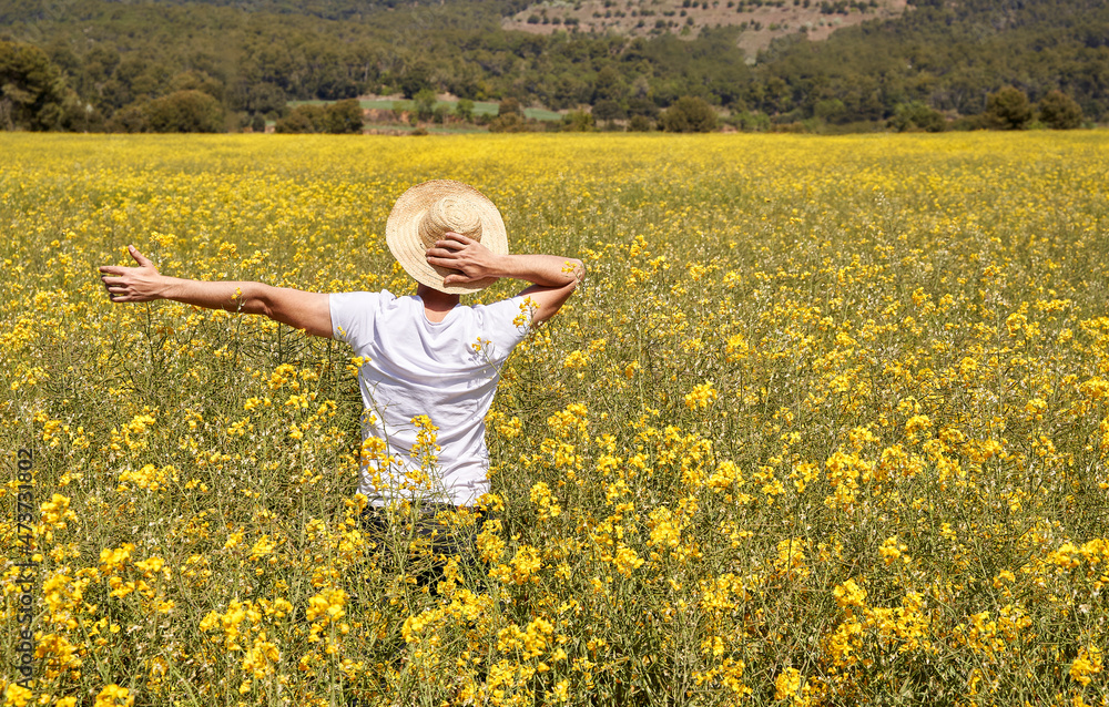 Man holding hat standing in field during sunny day Man holding hat standing in field during sunny day