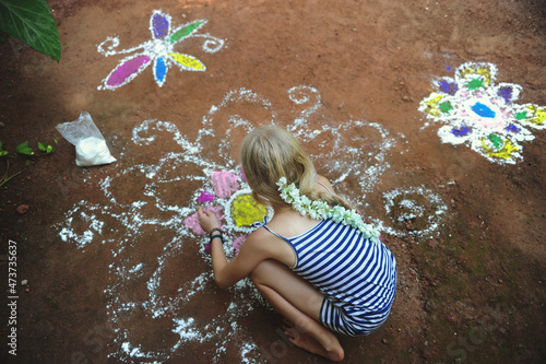 A girl creates a large mandala on the ground photo