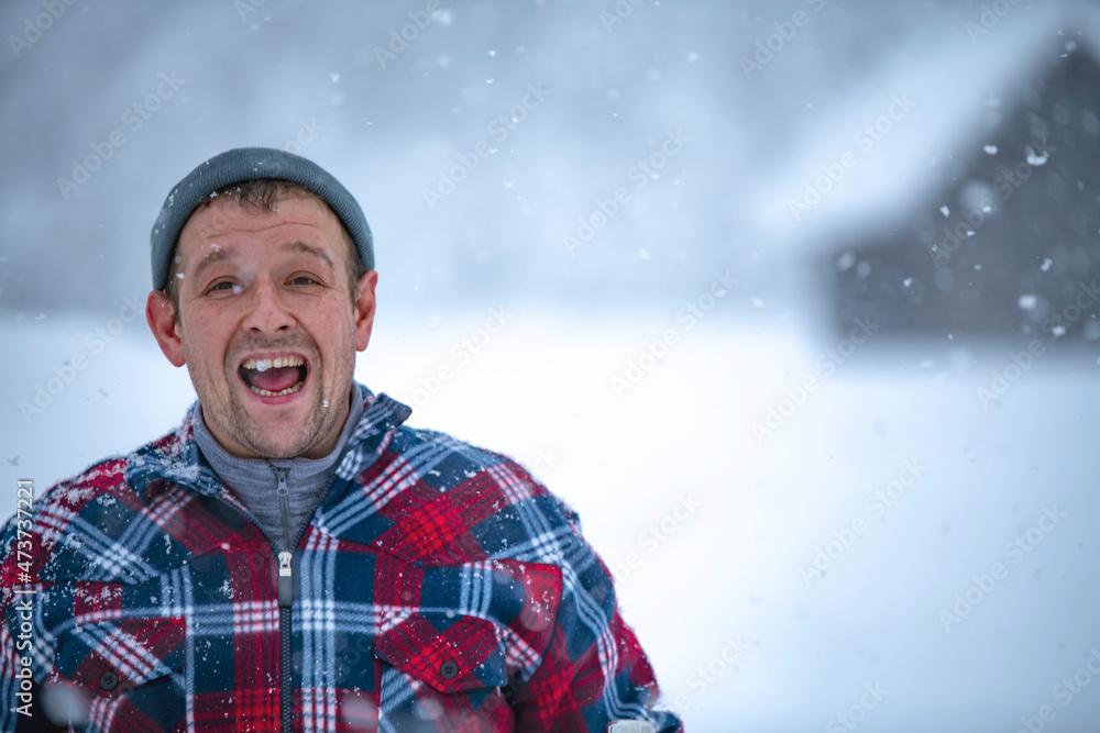 a man in a red check jacket is holding a cup of tea in his hands during a snowfall against the backdrop of beautiful snowdrifts and a forest a man in a red check jacket is holding a cup of tea in his hands during a snowfall against the backdrop of beautiful snowdrifts and a forest