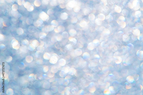 bright glitter background: bokeh effect from many colored lights on frozen glass, toning