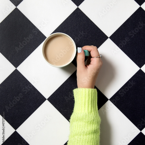 hand holding coffee cup on a black & white background