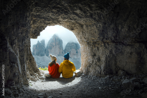 Картината върху платно Couple of mountaineers observe the views of Tre Cime di Lavadero from inside a c