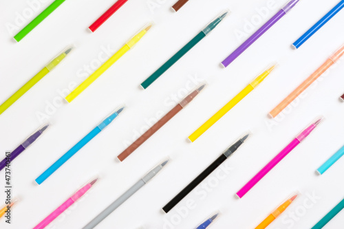 A set of multi-colored markers arranged diagonally with copy space. Colorful markers on white background, Flat lay. The concept of education and creativity.
