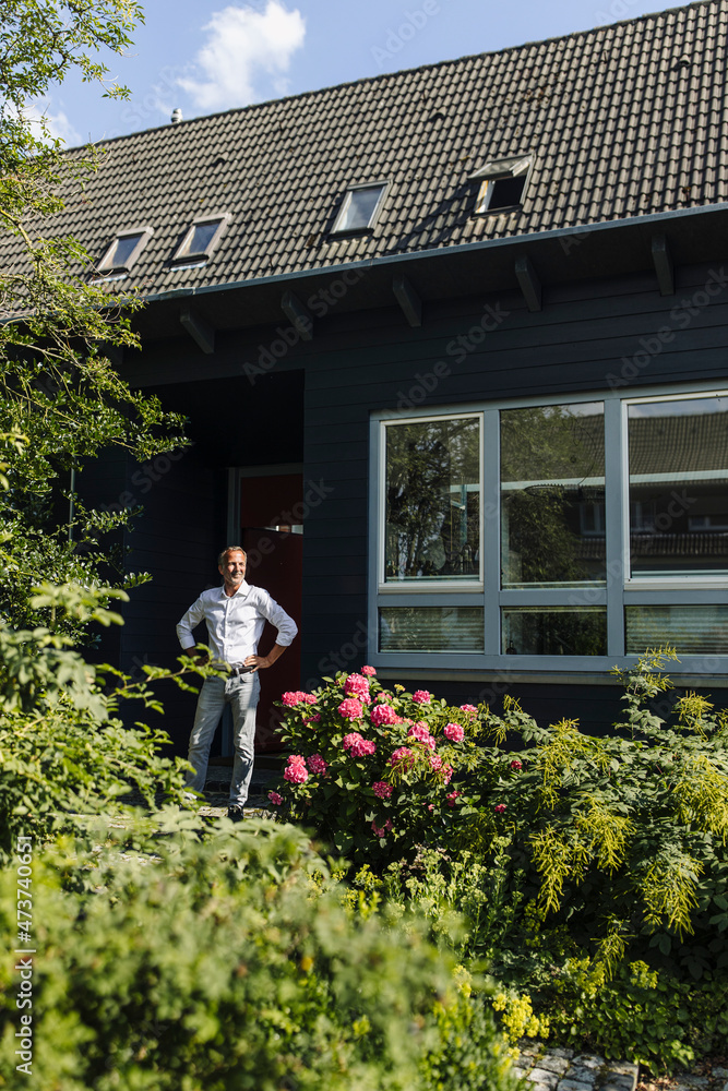 Man standing near house during sunny day Man standing near house during sunny day