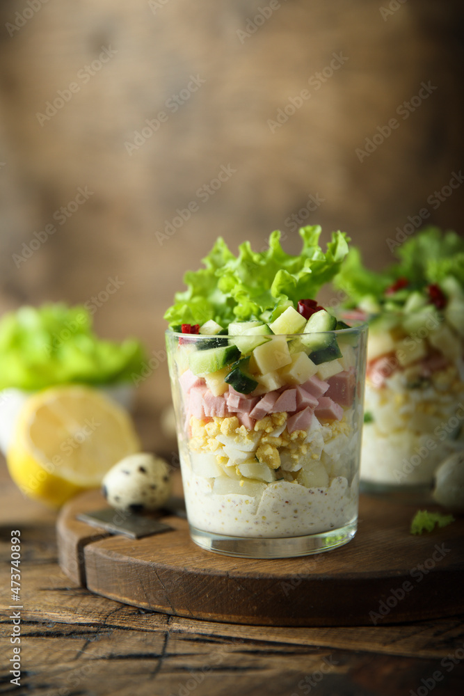Green salad with ham and cheese served in a glass Green salad with ham and cheese served in a glass