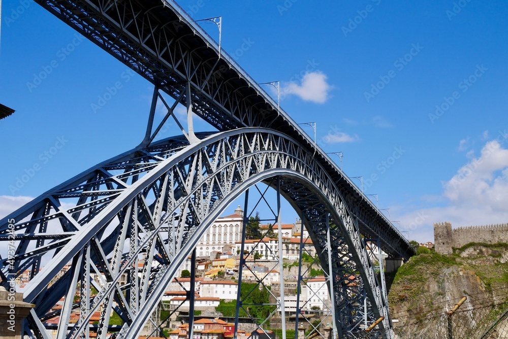 Low angle view of famous Dom Louis I bridge over river Douro and Villa Nova de Gaia on a sunny day. Porto, Portugal.