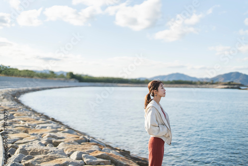 海岸沿いを散策する女性 © peach100