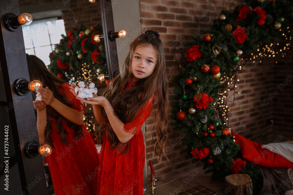 Cute little girl in red dress posing near mirror Stock Photo | Adobe Stock
