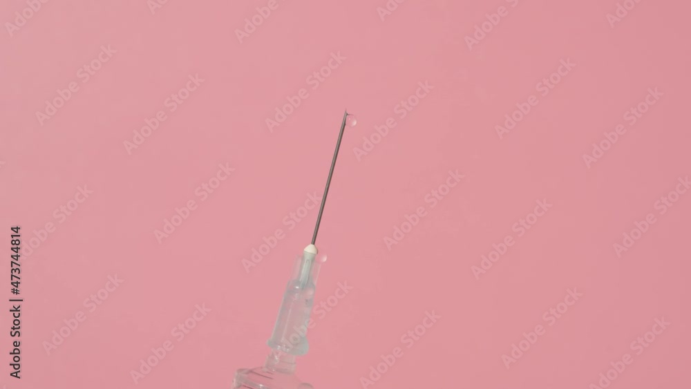 Shooting medicine with a syringe against a pink background Shooting medicine with a syringe against a pink background