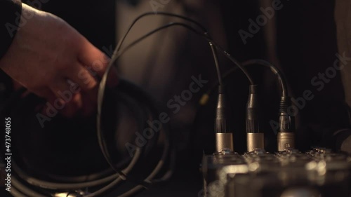 audio technician connects cables for live event. Concept of preparing concerts, conferences, performances. Behind the scenes