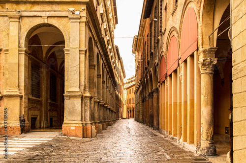 Beautiful Italian street  colourful buildings with porticos. Bologna  Italy.