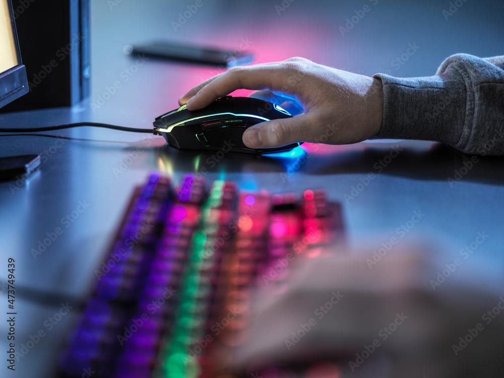 Boy using illuminated gaming mouse while playing video game Stock Photo ...