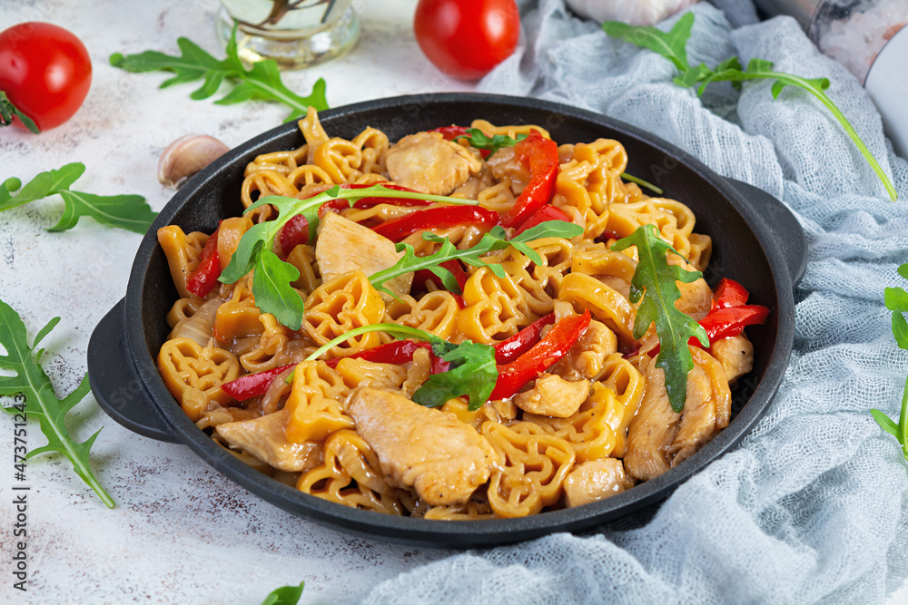 Tasty pasta in tomato sauce with chicken, pepper and herbs on white background Tasty pasta in tomato sauce with chicken, pepper and herbs on white background