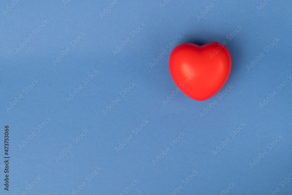 Rubber red heart on a blue background with space for text. 