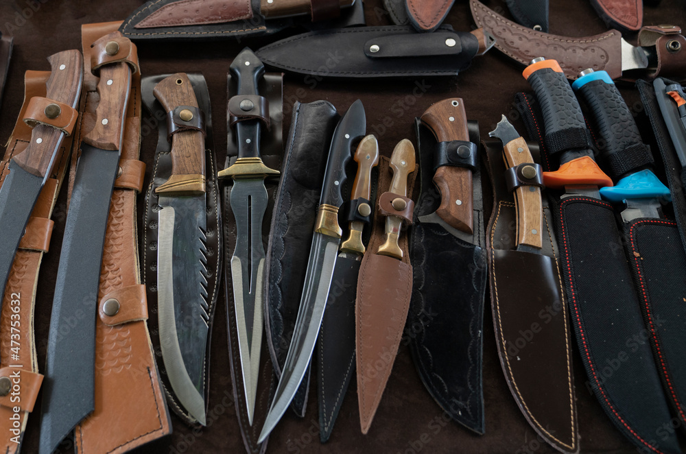 Many hunting knives and leather sheaths on sale at flea markets